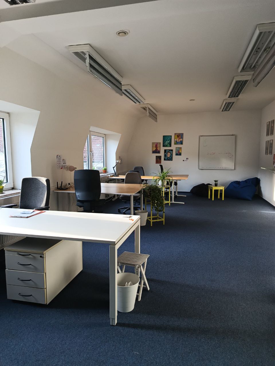 Coworking-Space mit drei Schreibtischen und zwei Sitzsäcken in den Räumlichkeiten der blau:pause Flensburg.