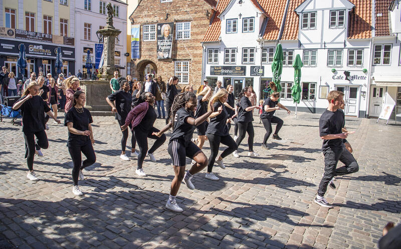 Eine Tanzgruppe tritt auf dem Nordermarkt in Flensburg auf.