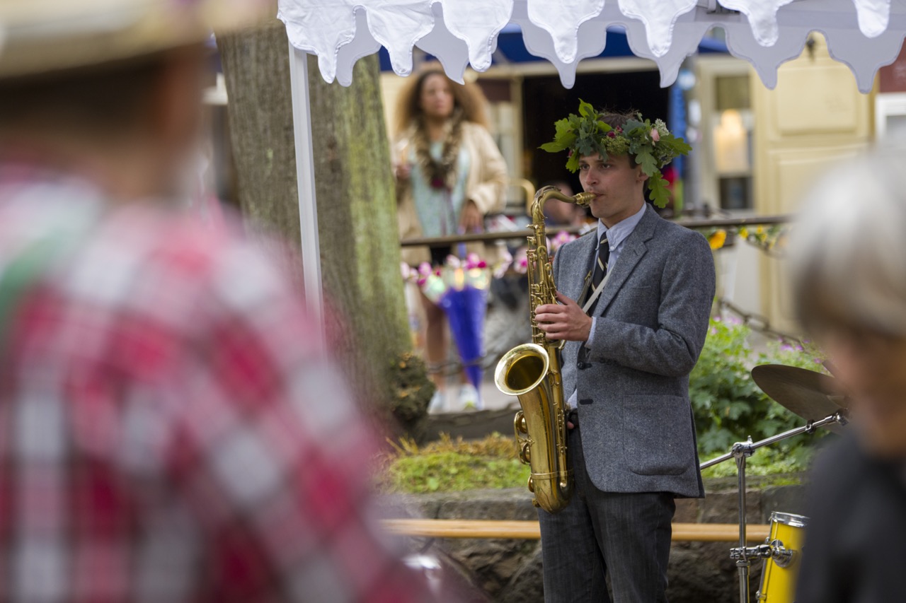 Saxophonspieler mit einem Blätterkranz im Haar.